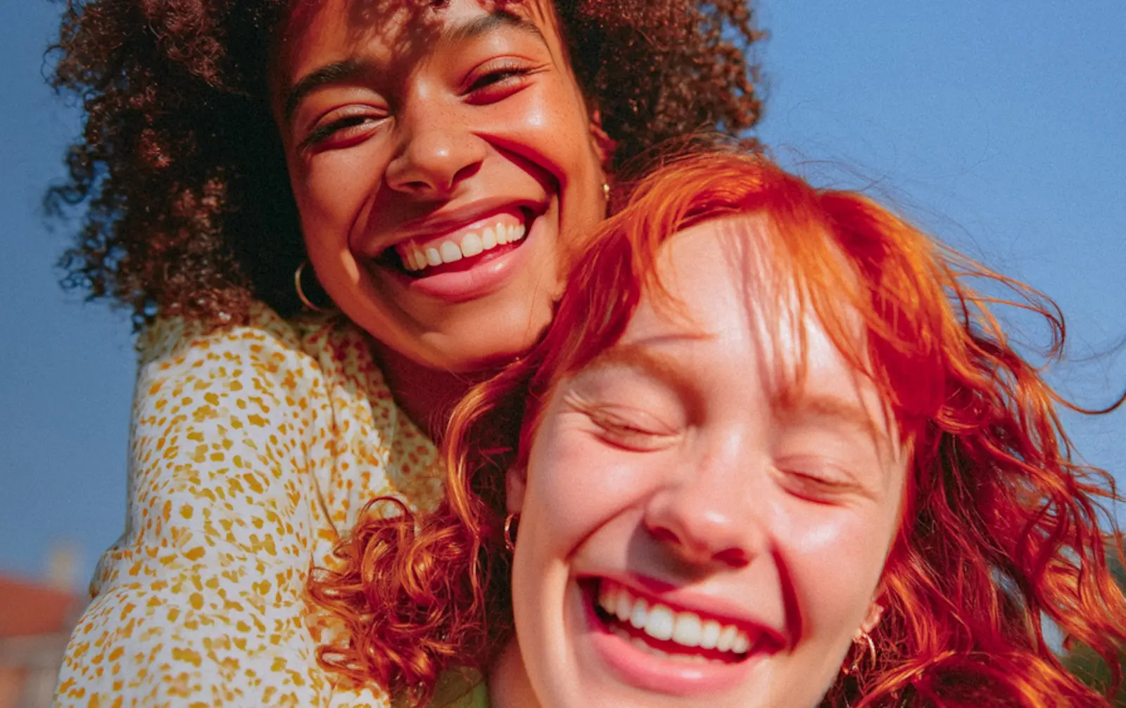 Two friends laughing together in the sun