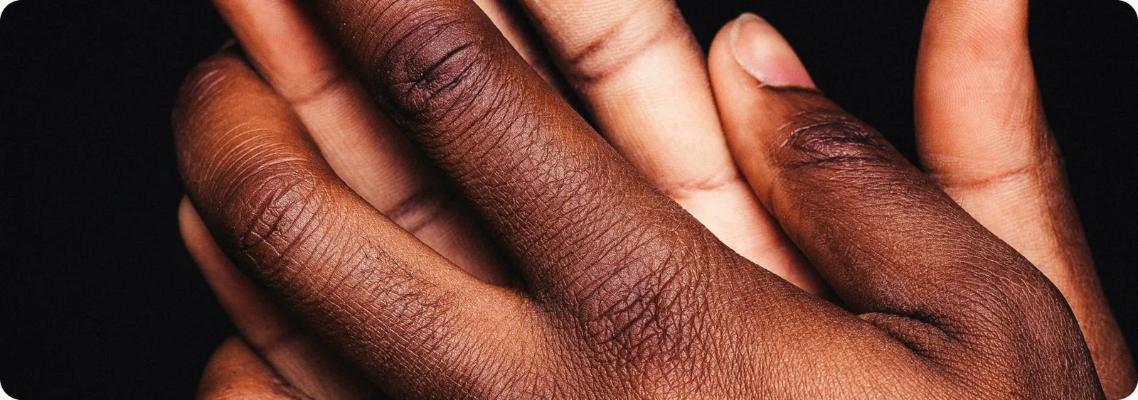 Two hands with different skin tones resting together