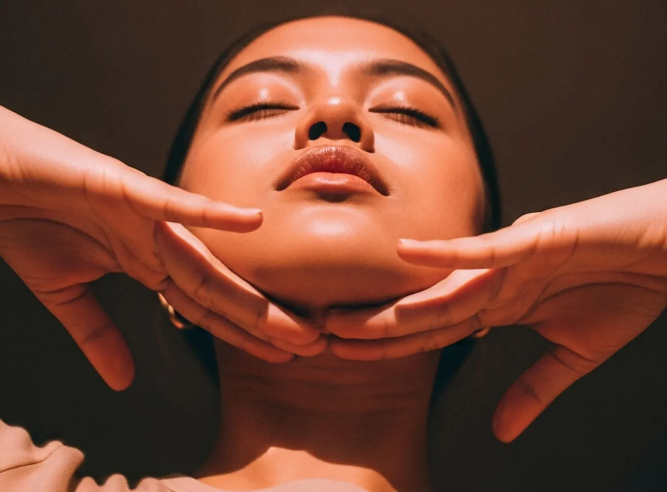 Woman with eyes closed, hands framing her face